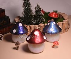 three colorful mushrooms sitting on top of a table next to a christmas tree and other decorations