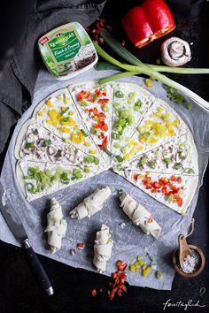 a pizza sitting on top of a pan covered in toppings next to a knife