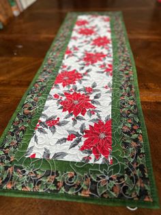 the table runner has red flowers on it