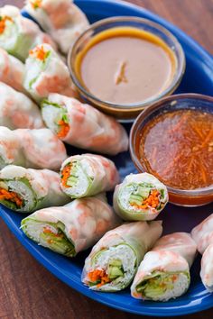 there are many rolls on the plate with dipping sauce