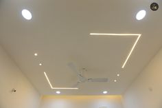 an empty room with white walls and ceiling lights on the ceiling is lit by recessed lighting