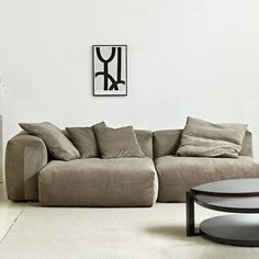 a living room with a large sectional couch and coffee table in front of the wall