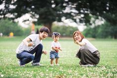 three young children are playing in the grass