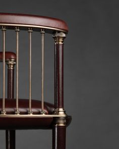 a wooden chair with metal bars on the back and armrests, against a gray background