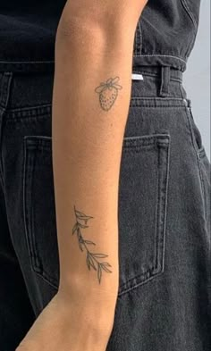 a woman's arm with a tattoo on it and an apple in the background