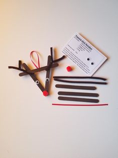 some scissors are laying next to each other on a white surface with red string and pins