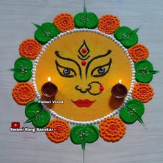 a decorated wall hanging with an image of the face of lord ganeshra on it