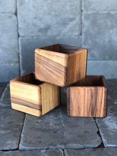 three wooden boxes sitting on top of a stone floor