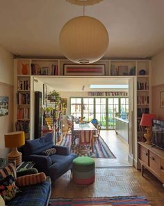 a living room filled with lots of furniture and bookshelves next to a doorway