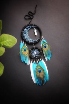 a necklace with feathers hanging from it's side on top of a black surface