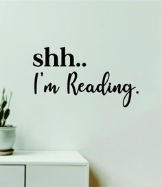 the words shh i'm reading are written in black on a white wall