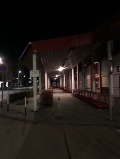 an empty gas station at night with no people on the sidewalk or in front of it