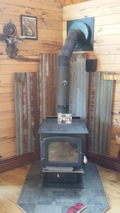 a wood stove in a room with wooden walls and flooring on either side of it