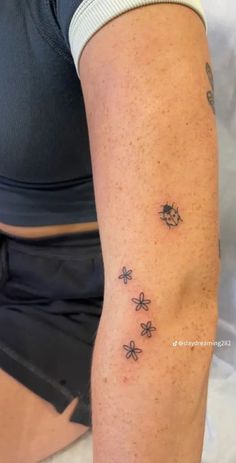 a woman's arm with small tattoos on it