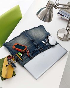 an open laptop computer sitting on top of a white desk next to a pile of assorted items