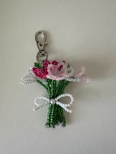 a bunch of flowers that are sitting on a keychain with some beads attached to it