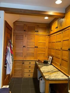 a kitchen with wooden cabinets and marble counter tops