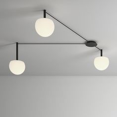 three lights are hanging from the ceiling in an empty room