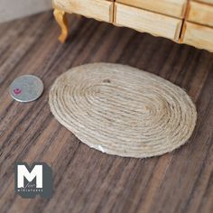 a round rope on the floor next to a small drawer with a coin in front of it