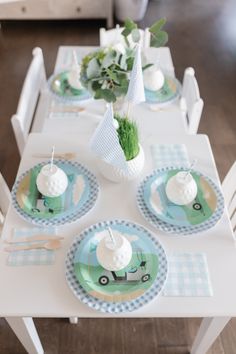 the table is set with blue and white plates, green napkins, and greenery