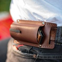 a man wearing a leather belt with a cell phone in his pocket