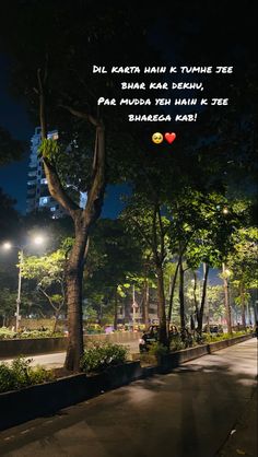 a city street at night with trees and buildings in the background that reads, dil karta hain k tume tree