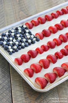 an american flag cake with strawberries and blueberries in the shape of the american flag