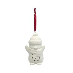 a white ornament with a red ribbon hanging from it's side and a snowman hat on top