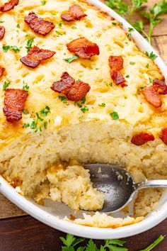 a casserole dish with bacon and cheese in it on a wooden table next to parsley