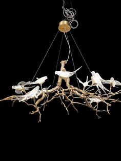 a chandelier made out of branches with birds on it