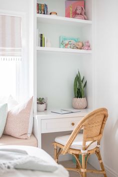 a bedroom with a bed, desk and shelves filled with books on top of it