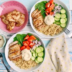 two bowls filled with chicken, rice and veggies on top of a table