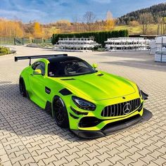 a lime green mercedes sports car parked in front of a building