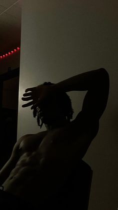 a man with dreadlocks sitting in a dark room