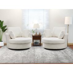 two white chairs sitting on top of a rug