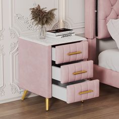 a pink nightstand with three drawers and a plant on top