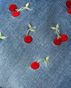 the fabric has cherries embroidered on it