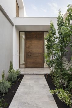 the entrance to a modern house with wooden doors