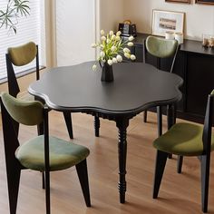 a black table with green chairs around it