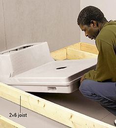 a man kneeling down on the floor with a laptop computer in it's lap