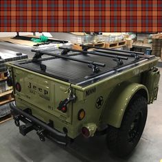 an army green truck parked in a warehouse