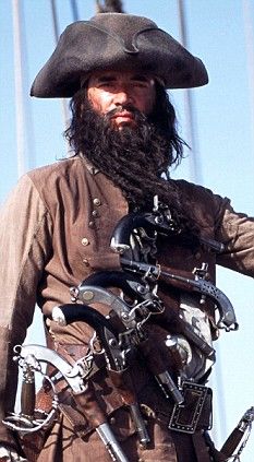 a man with a long beard wearing a pirate outfit and holding a bike in his hand