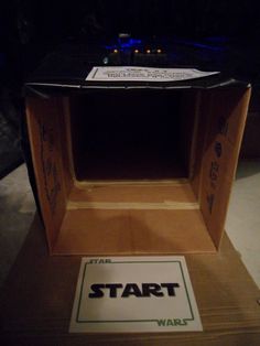 a cardboard box with the words start on it and a sign that says star wars