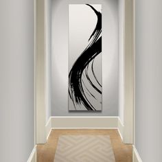 an abstract painting hangs in the corner of a hallway