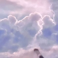 an airplane is flying in the sky with clouds