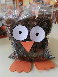 an owl made out of brown paper sitting on top of a table