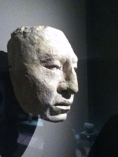 an ancient head is on display in a museum