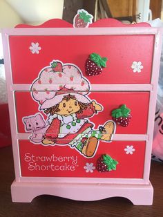 a strawberry shortcake card on a pink wooden box with red and green trimmings