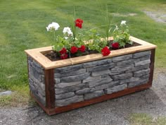 a stone planter with red and white flowers in it