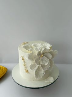 a white cake sitting on top of a table next to a yellow plate and banana